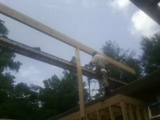 Carpenter setting a ridge beam over a new addition frame — Ice Dam Removal by Roofing Brothers in Alta Vista