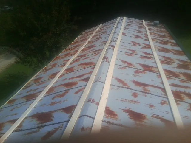 Rusted metal roof panels with new wood purlins before replacement — Storm Damage Roof Repair in Alta Vista by Roofing Brothers
